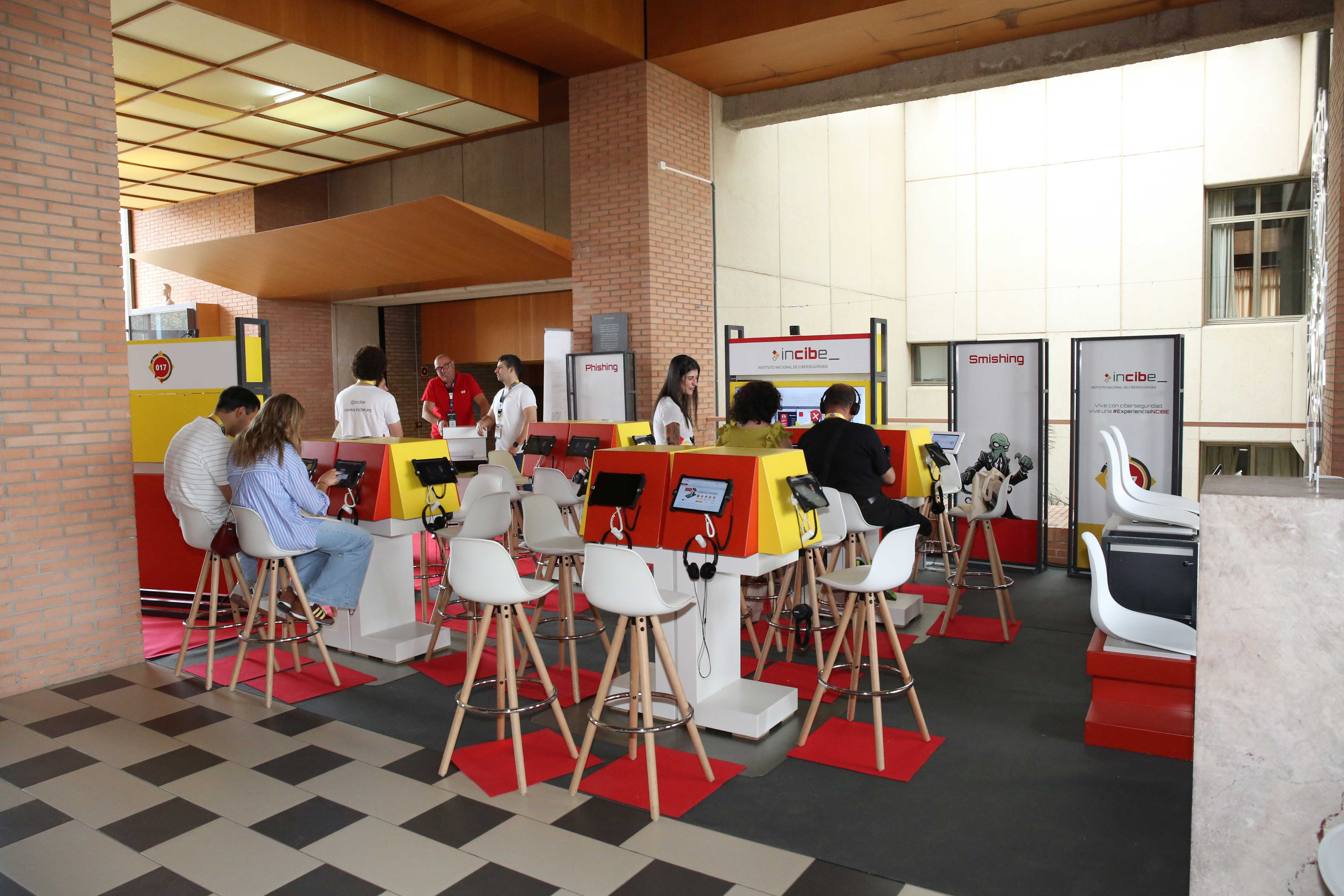 Fotografía del stand de Incibe con varios asistentes al congreso C1b3erWall utilizando unas tablet.