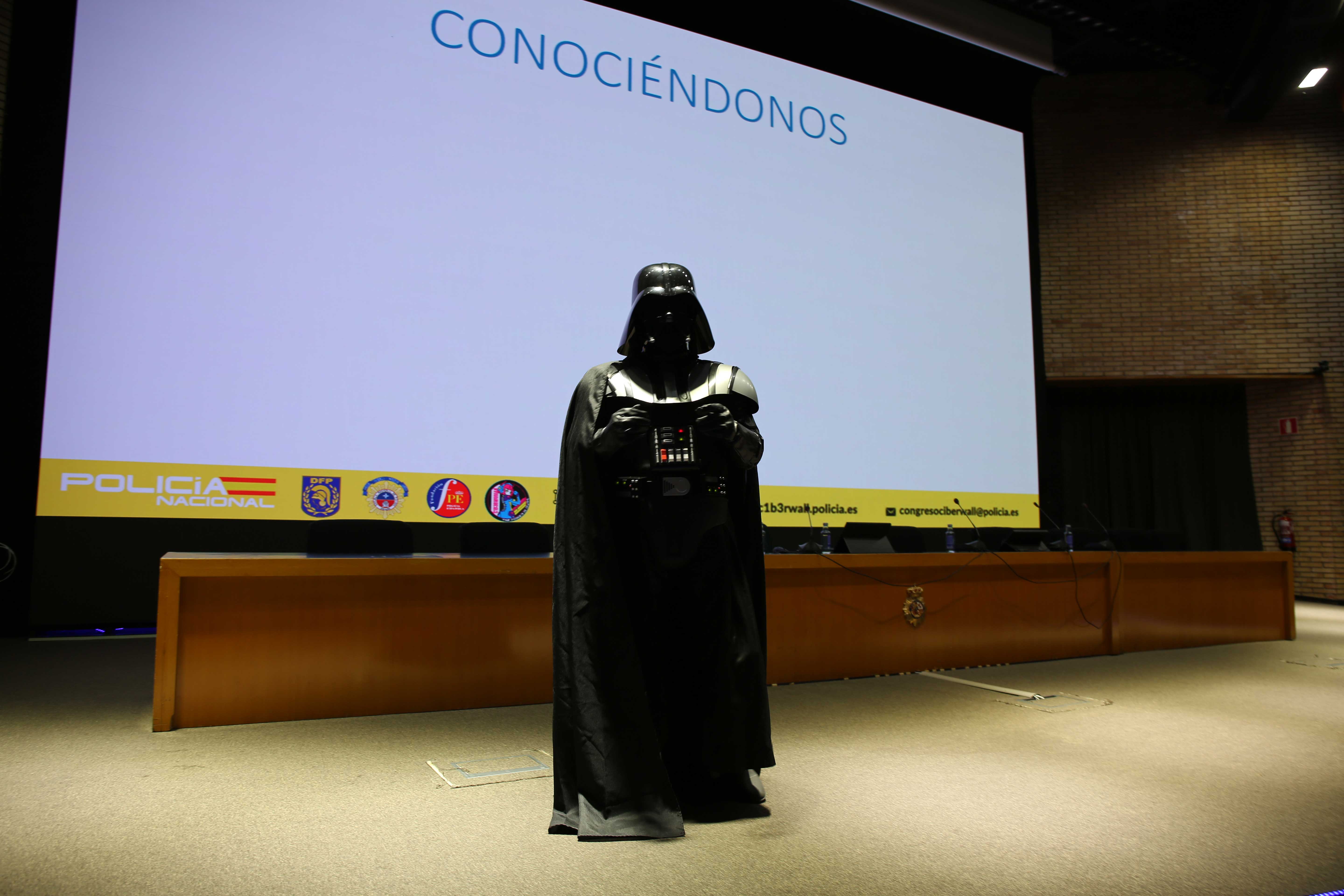 Fotografía de una persona disfrazado de Darth Vader dando una conferencia a jóvenes en el congreso C1b3rWall 2024